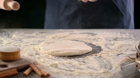Baker rolls dough with rolling pin on a cutting table. Video stock 130532638
