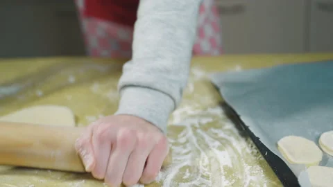 Baker rolls out the dough with a rolling pin on the table. Selective Focus Video stock 169286906