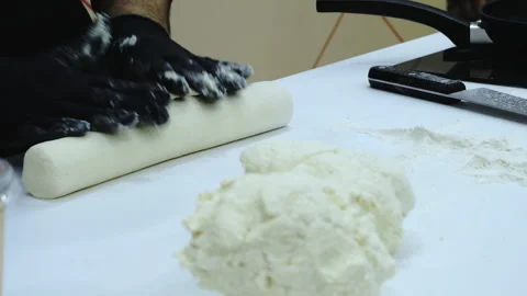 The baker rolls out the dough on the table. Stock Footage 171851873