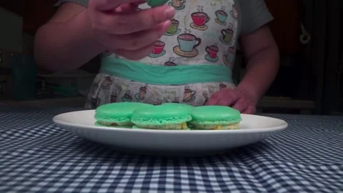 Baker sets down plate of macarons and takes a bite Video stock 168469708