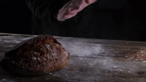 The baker shakes his hands from the flour against the background of fresh whole Stock Footage 167791982