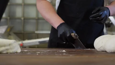 Baker shapes bread from dough on a table with flour. Vídeos de archivo 313535005