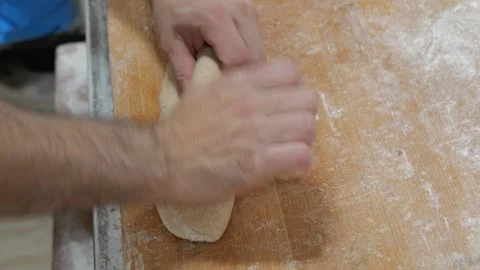 Baker shaping bread dough by hand Stock Footage 334564434
