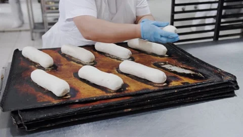 Baker Shaping Dough Rolls On Tray. Bakery production Stock Footage 321691903