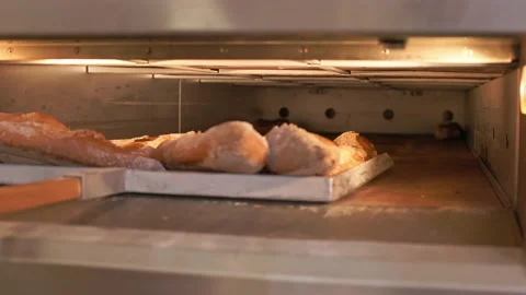 The baker shovels bread from the oven Stock Footage 155522944