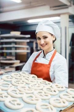 Baker showing sheet with bread ready to be baked Stock Photos