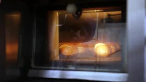 A baker is shown watching the process of baking bread. Video stock 200402190