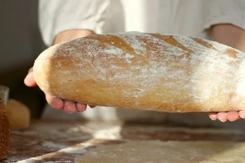 Baker shows fresh-baked bread Stock Footage 10735064
