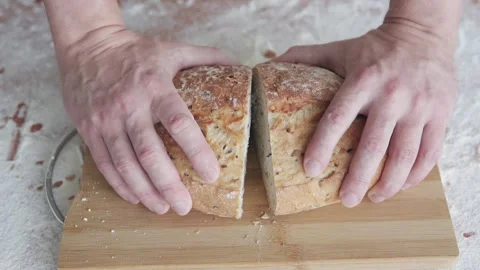 The baker shows off a slice of fresh, crispy bread straight from the oven. Stock Footage 301287820