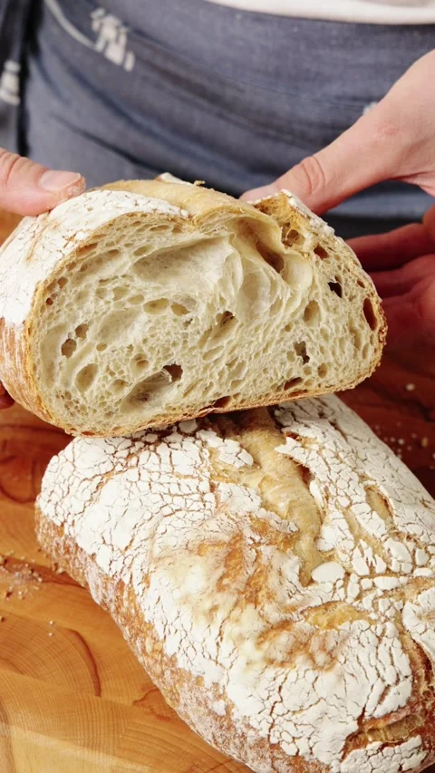 Baker shows sourdough bread crumb to camera. Video stock 344769756