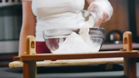 Baker sifting flour into a bowl at a kitchen workstation, 4K Stock Footage 341120808