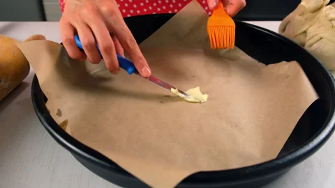 Baker spreading butter on baking paper in baking tray cooking on kitchen. Video stock 313045873