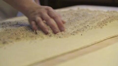 Baker spreading stuffing over the flattened dough Stock Footage 87613039