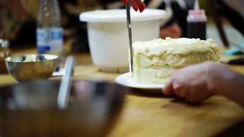 A baker spreads cream on top cake. make the cake Video stock 72256792
