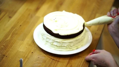A baker spreads cream on top cake. make the cake Video stock 72256908