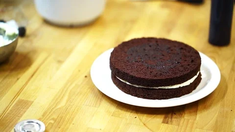 A baker spreads cream on top cake. make the cake Video stock 72256963