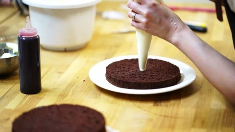 A baker spreads cream on top cake. make the cake Video stock 72256972