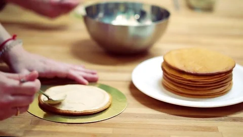 A baker spreads cream on top cake. make the cake Video stock 72256996