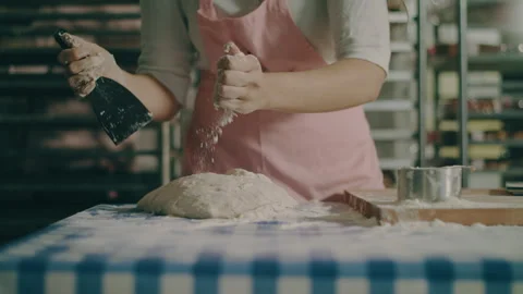 Baker spreads flour over the top of dough Stock Footage 274650526