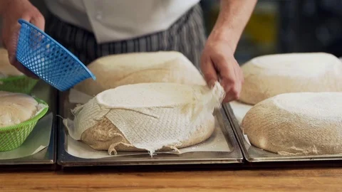 The baker spreads the raw bread out of the molds and prepares it for Video stock 125077433