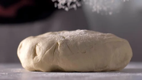 The baker sprinkles the dough with flour Stock-Footage 106152796