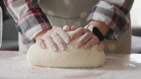 A baker sprinkles flour on a table and kneads dough for homemade baking Stock Footage 318160543