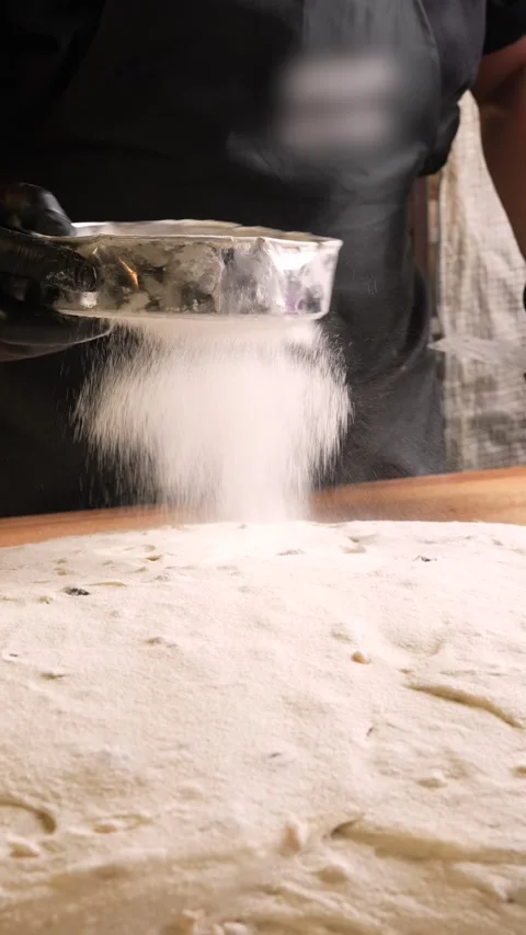 The baker sprinkles the muse through a sieve on the dough Stock Footage 261250414