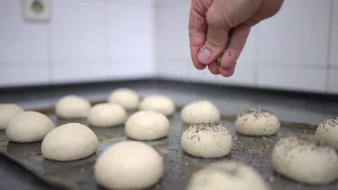 Baker sprinkling bread rolls with seeds super slowmotion 스톡 동영상 251368220