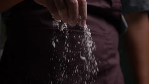 Baker sprinkling flour into dough on table Stock-Footage 132678417