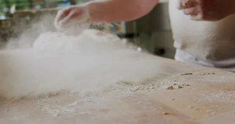 Baker sprinkling flour on table 4K. Stock Footage 221561923