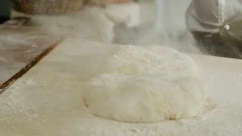 A baker sprinkling a loaf of bread with flour 4k Stock Footage 86893139