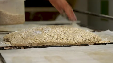 Baker Sprinkling Oats On Bread Dough Stock Footage 340934292