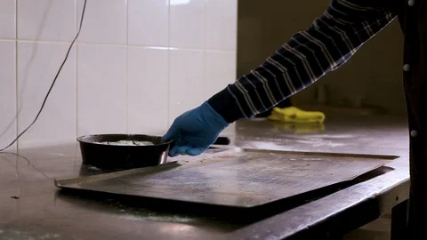 Baker takes away a tray with bakeware Vidéo 106461253