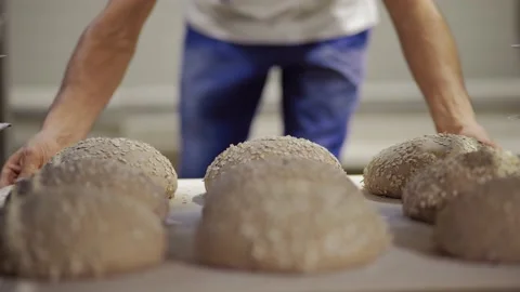 The baker takes the bread from the dough off the shelf Stock Footage 143980430