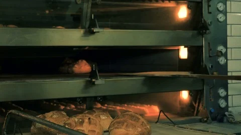 The baker takes bread out of the oven. Ready-made bakery products. Stock Footage 82715411