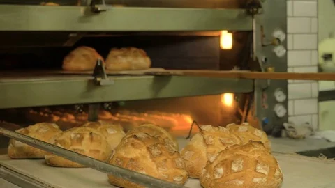 The baker takes bread out of the oven. Ready-made bakery products. Stock Footage 82715720