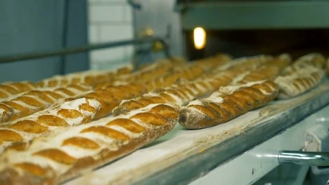 The baker takes bread out of the oven. Ready-made bakery products. Stock Footage 82715806