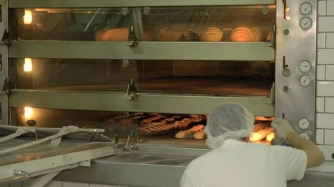 The baker takes bread out of the oven. Ready-made bakery products. Stock Footage 82716280