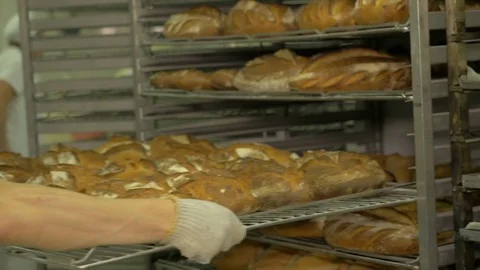 The baker takes bread out of the oven. Ready-made bakery products. Stock Footage 82716462