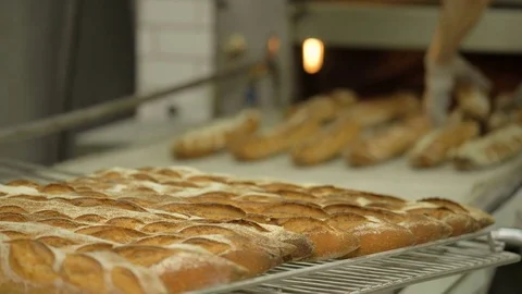 The baker takes bread out of the oven. Ready-made bakery products. Stock Footage 82716579