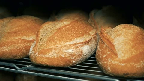 The baker takes bread out of the oven. Ready-made bakery products. Stock Footage 82716990