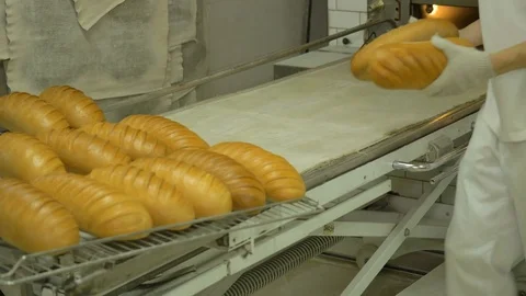 The baker takes bread out of the oven. Ready-made bakery products. Stock Footage 82717625