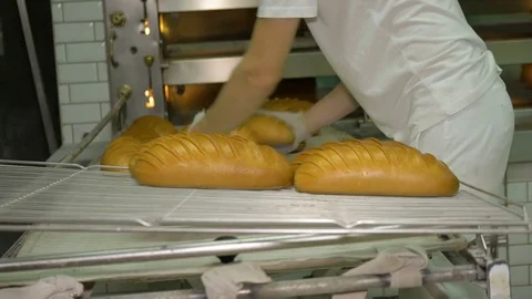 The baker takes bread out of the oven. Ready-made bakery products. Stock Footage 82717805