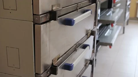 Baker takes the freshly baked bread out of the oven Stock Footage 130895217