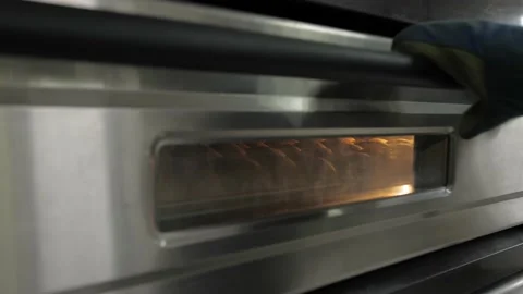 Baker takes the freshly baked bread out of the oven Stock Footage 132089290