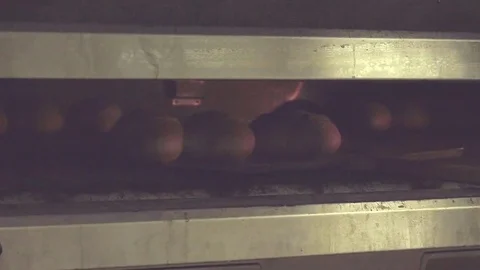 Baker takes out of oven freshly baked bread loaf HD slow-motion bakery video Stock Footage 74727637