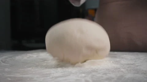 The baker throws a piece of dough on a board with flour. slow motion Stock Footage 201547296