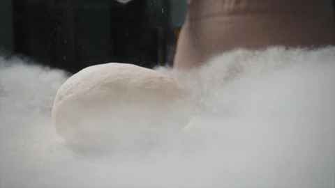 The baker throws a piece of dough on a board with flour. slow motion Stock Footage 201547508