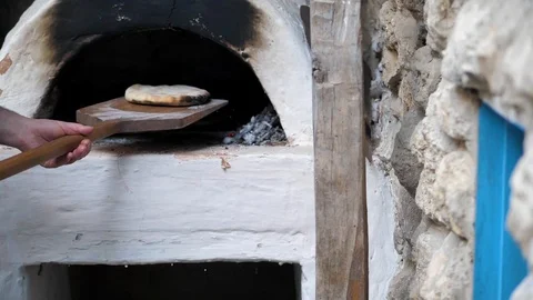 The Baker took the baked flatbread out of the oven with a wooden spatula Stock Footage 125523697