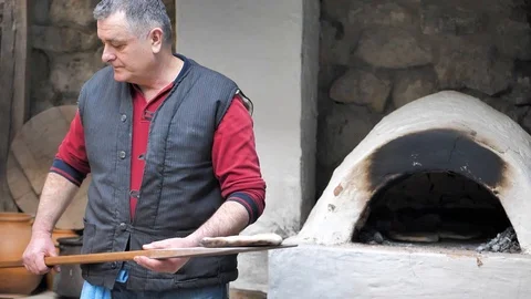 The Baker took the baked flatbread out of the oven with a wooden spatula Video stock 125523712